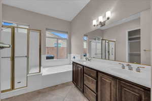 Full bathroom featuring a bath, a stall shower, double vanity, and light tile patterned floors