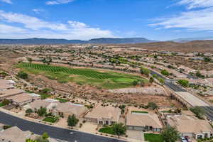 Aerial perspective of suburban area with a mountainous background and a golf club