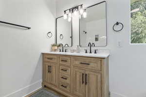Bathroom with double vanity and baseboards