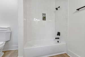 Full bath with shower / bathtub combination and light wood-type flooring