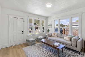 Living area with wood finished floors and a textured ceiling