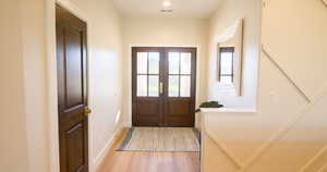 Doorway with wood finished floors and french doors