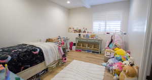 Bedroom featuring wood finished floors and beam ceiling