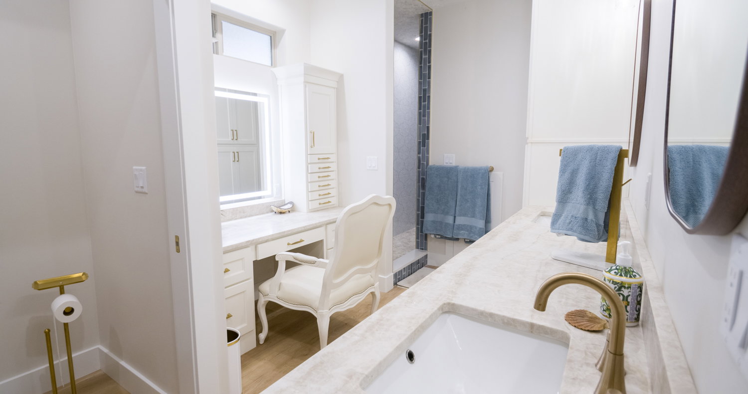 Full bath with double vanity and light wood-style flooring