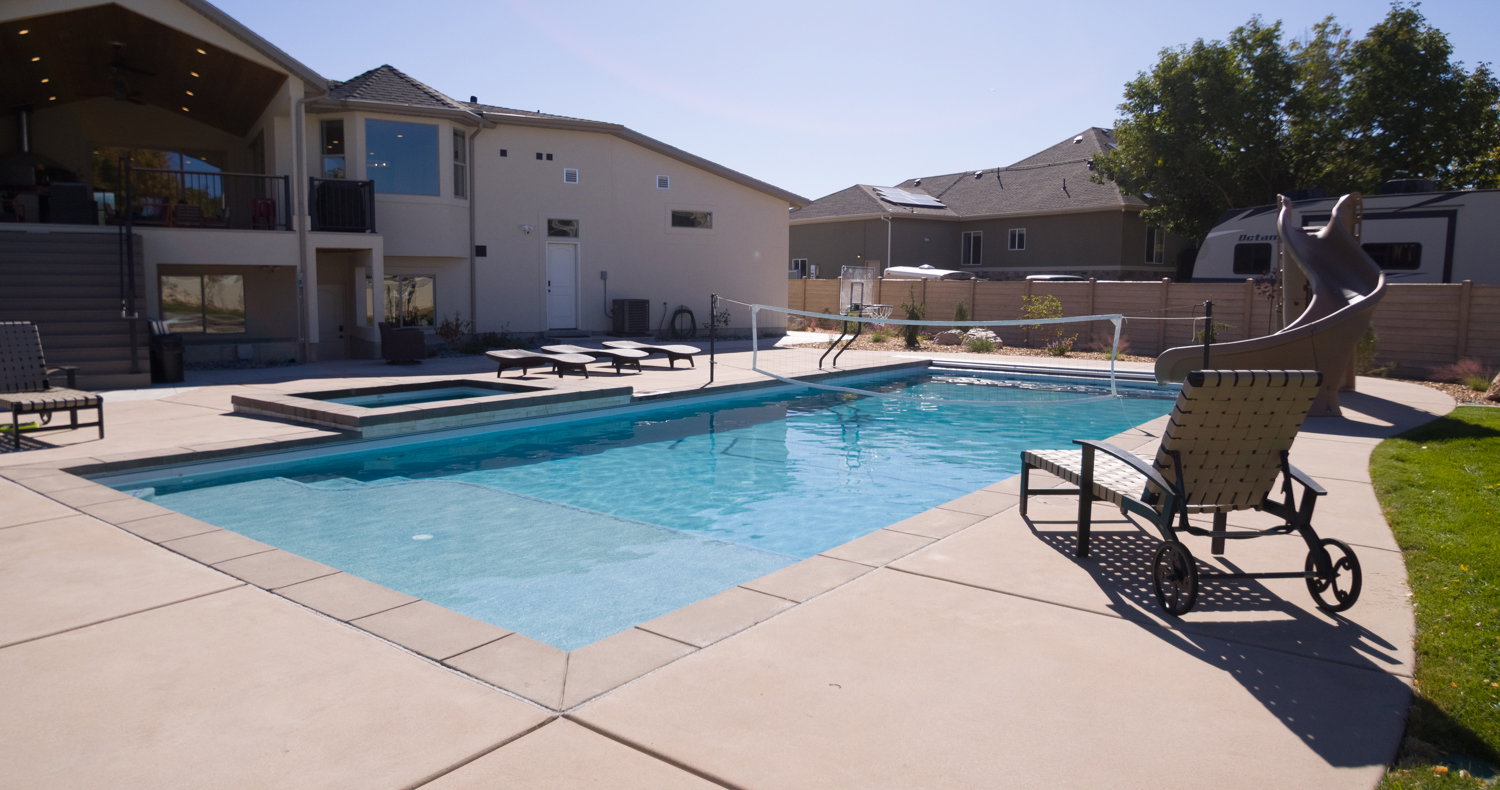 View of swimming pool with a patio, a balcony, a pool with connected hot tub, and a residential view