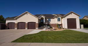 View of front of house featuring driveway, stucco siding, and a garage