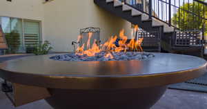 Exterior view of stucco siding, a fire pit, and stairway