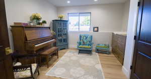 Sitting room with light wood finished floors and recessed lighting