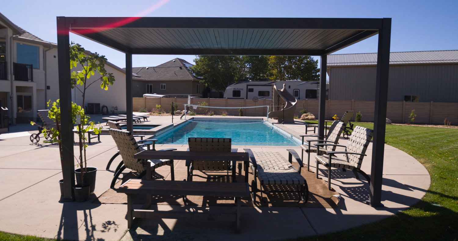 View of pool featuring a patio area, a water slide, a fenced backyard, and a pool with connected hot tub