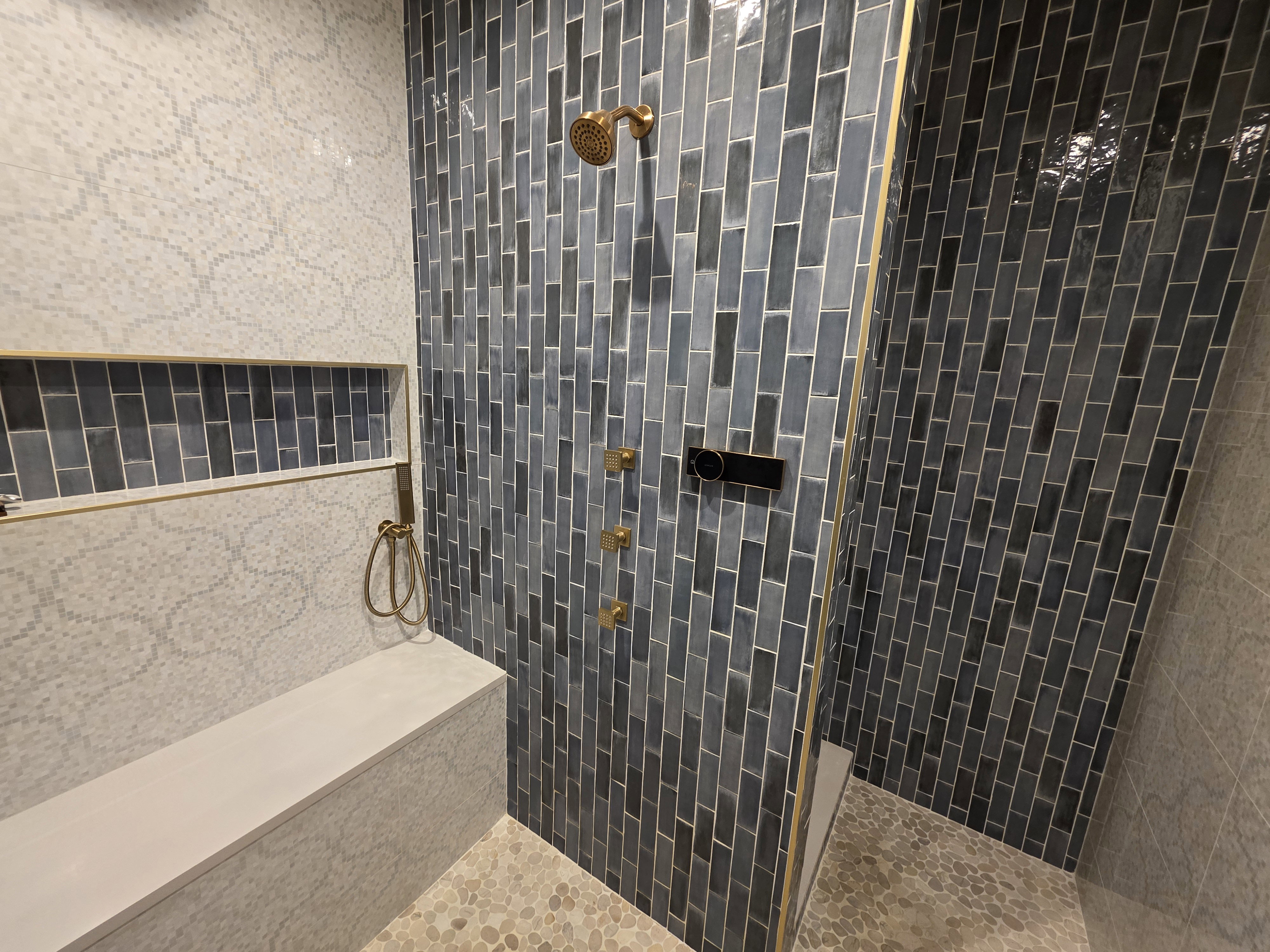 Bathroom featuring tiled shower and tile walls