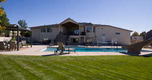 Swimming pool with stairs, a water slide, a patio area, and a balcony