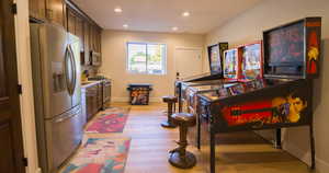 Kitchen with appliances with stainless steel finishes, light wood-style flooring, light countertops, recessed lighting, and dark brown cabinetry