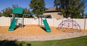 View of jungle gym with a fenced backyard