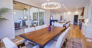 Dining room featuring light wood-style flooring, a chandelier, and recessed lighting