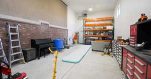 Miscellaneous room with a high ceiling, concrete flooring, and a heating unit