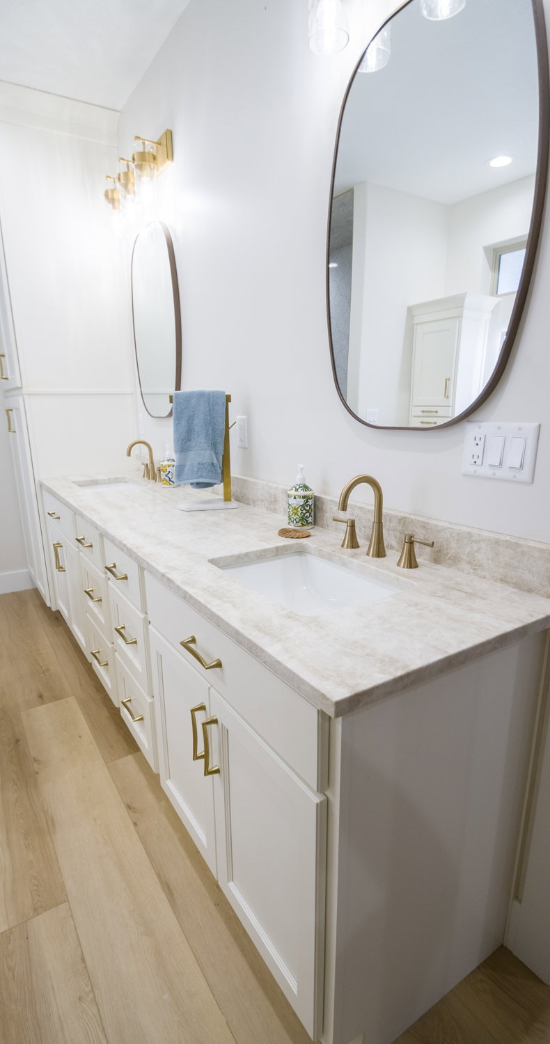 Full bath with light wood-type flooring and double vanity