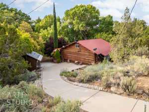 View of front facade with log exterior and a metal roof
