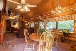 Dining room with carpet, rustic walls, and wood ceiling