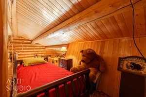 Bedroom featuring wooden ceiling and log walls