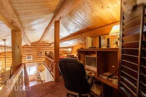 Office space with log walls, wooden ceiling, and carpet
