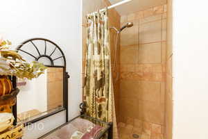 Bathroom featuring a textured wall and a shower stall