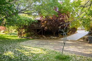 View of grassy yard featuring a wooden deck