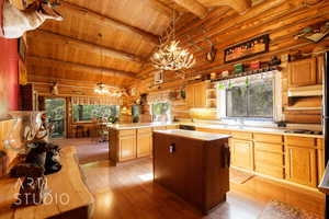 Kitchen with light countertops, open shelves, light wood finished floors, pendant lighting, and a wooden ceiling with exposed beams