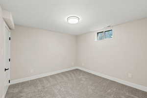 Basement featuring baseboards and light carpet