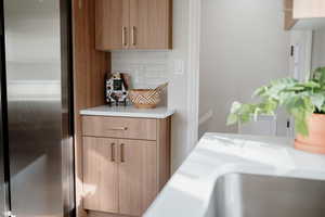 Detailed view of stainless steel fridge and tasteful backsplash