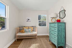 Bedroom featuring wood finished floors and a crib