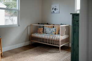 Bedroom featuring light wood-style floors and a nursery area