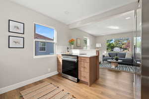 Kitchen featuring stainless steel appliances, light countertops, brown cabinets, modern cabinets, and light wood finished floors