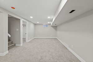 Basement with stairs, light carpet, and recessed lighting