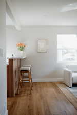 Living area with light wood-style floors, beam ceiling, and recessed lighting