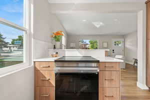 Kitchen featuring stainless steel range with electric cooktop, a peninsula, modern cabinets, recessed lighting, and light wood-style floors