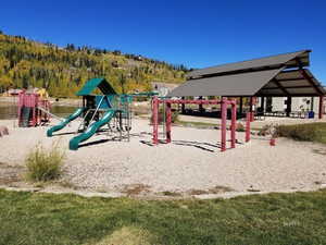 Communal playground with a patio area and a wooded view