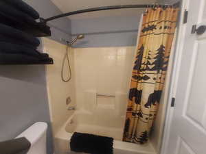 Full bathroom with shower / tub combo with curtain and toilet