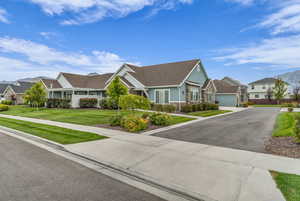 Single story home with stone siding, a residential view, a front yard, and stucco siding