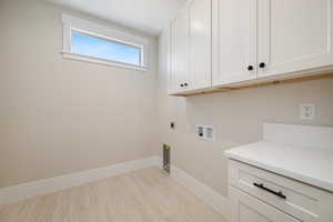 Laundry room featuring cabinet space, electric dryer hookup, and hookup for a washing machine