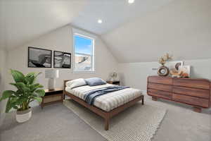 Bedroom with light colored carpet, vaulted ceiling, and recessed lighting