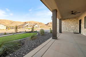 View of patio featuring a mountain view, a ceiling fan, and a residential view