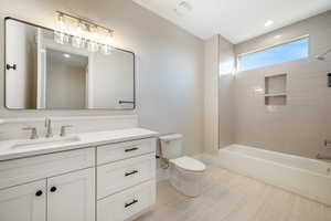 Bathroom with washtub / shower combination, vanity, and recessed lighting