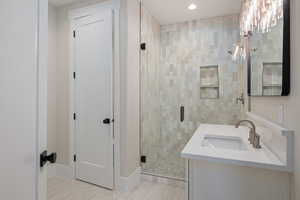 Full bathroom featuring a stall shower, vanity, and recessed lighting