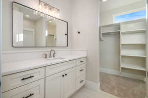 Bathroom featuring vanity and a spacious closet
