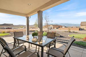 View of patio / terrace featuring a mountain view, outdoor dining space, and a residential view