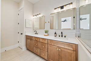 Bathroom with double vanity and baseboards
