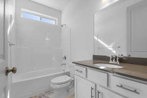 Bathroom with bathing tub / shower combination, vanity, and light wood-style floors