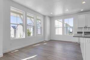 Unfurnished dining area with recessed lighting, dark wood-style floors, and a textured ceiling