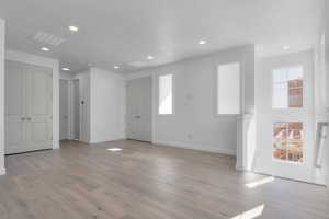 Foyer with recessed lighting, light wood-type flooring, and a textured ceiling