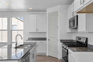 Kitchen featuring appliances with stainless steel finishes, light wood-style flooring, white cabinets, recessed lighting, and a textured ceiling